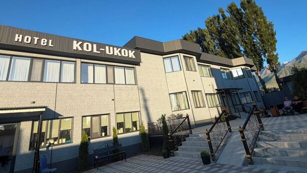 Un hotel llamado 'HOTEL KOL-UKOK' con un estilo arquitectónico moderno, que presenta fachada de ladrillo, ventanas amplias y una escalera que conduce a la entrada.