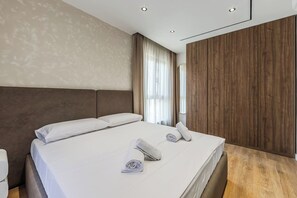 Ein Hotelzimmer mit einem großen Bett, einer Wand aus Holzpaneelen und einem Fenster mit Vorhängen.
