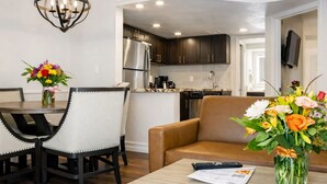 A modern living room with a dining area, a sofa, a coffee table, and a kitchen in the background. - Cozy 1-bedroom hotel with AC in charming Las Vegas (Las Vegas)