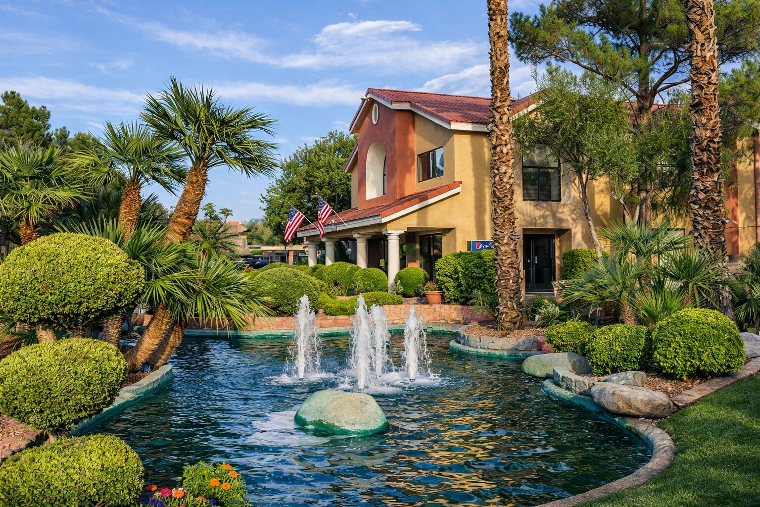 A hotel with a fountain, palm trees, and well-maintained landscaping.