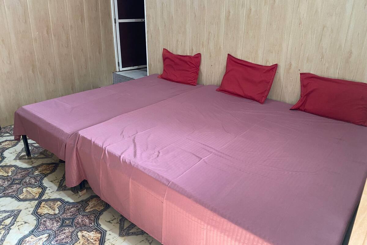 A room with a large bed, a wardrobe, and a patterned floor.