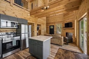 A wooden cabin interior with a kitchen, dining area, and living room. - Exclusive Smoky Mountains Cabin w/ hot tub & views (Sevierville)