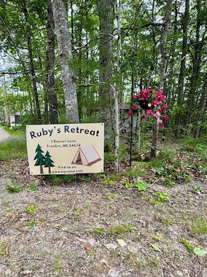 A sign for Ruby's Retreat with a tent illustration, located at 1 Beaver Lane, Franklin, ME 04634.