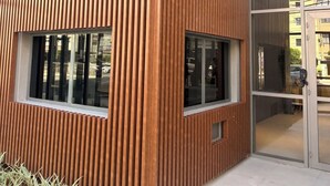 A modern building facade with vertical wooden slats and large windows. - Modern Studio in the Best Area of ​​Mooca (São Paulo)