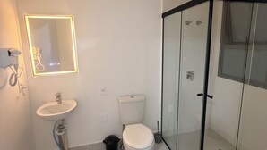 A bathroom with a sink, toilet, and glass-enclosed shower. - Modern Studio in the Best Area of ​​Mooca (São Paulo)