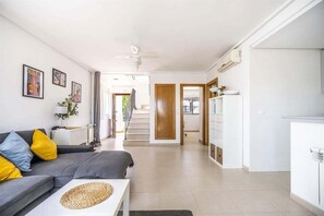Ein modernes Wohnzimmer mit einer Couch, einem Couchtisch und einer Treppe zu einem anderen Raum.