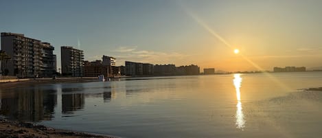 A calm waterfront with buildings in the background.