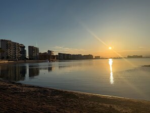 Una orilla tranquila con edificios al fondo.