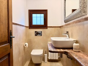 A bathroom with a toilet, sink, and mirror.