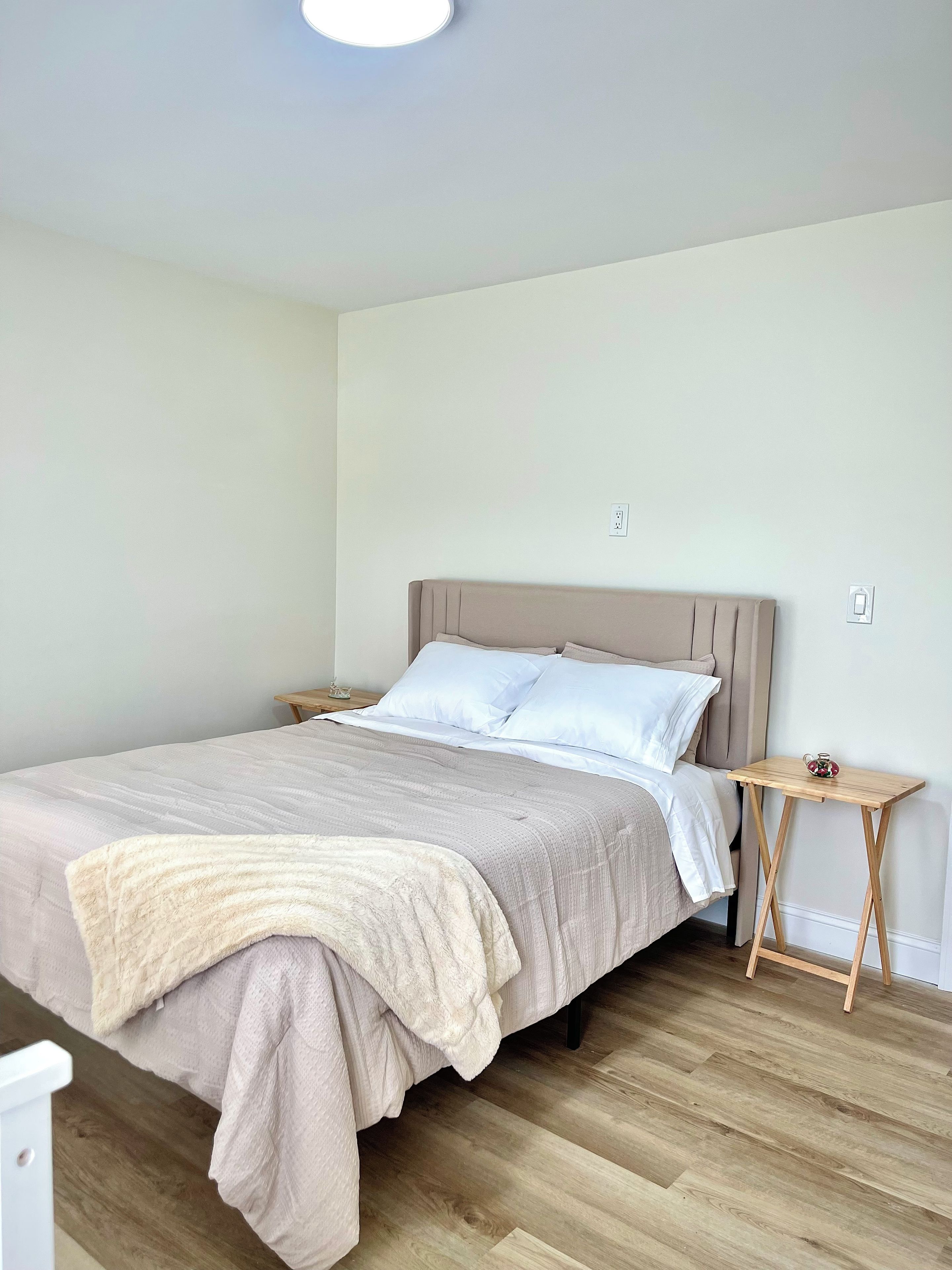 A bedroom with a bed, bedside tables, and a nightstand.