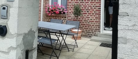 Una casa de ladrillo con un patio, una mesa y sillas.