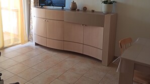 A modern living room with a TV, a dining table, and a sofa. - 2-room apartment, 45 m², ground floor, garden 50 m² + terrace 26 m² (Hyères)
