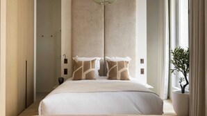A modern hotel room with a large bed, a pendant light, and a potted plant. - Luxurious Suite - AC- 2P- Madeleine/saint Honore (Paris)