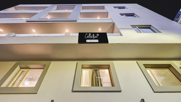 Een hotel met veel ramen en een bord boven de ingang.