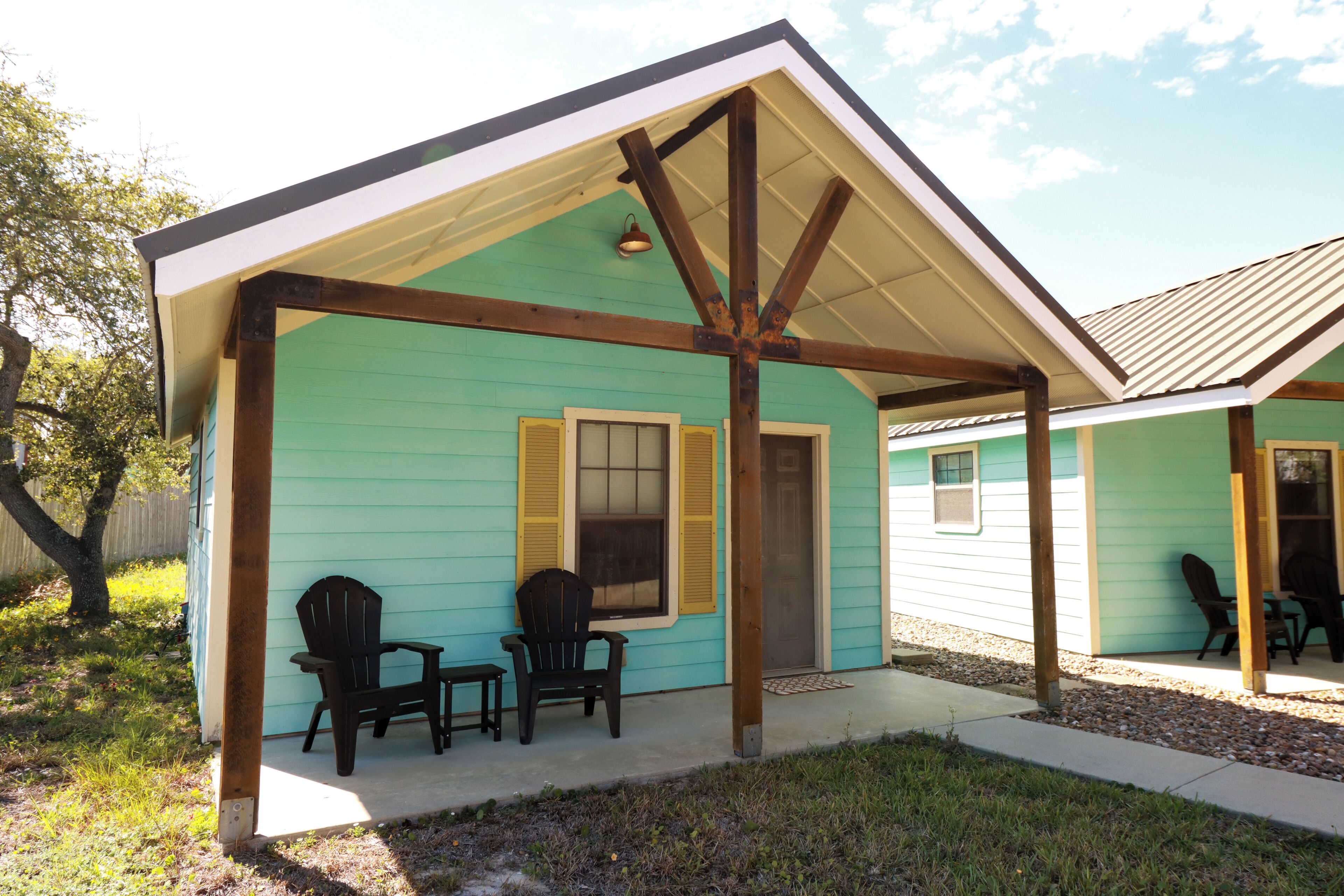 A house with a porch, two chairs, and a small table.