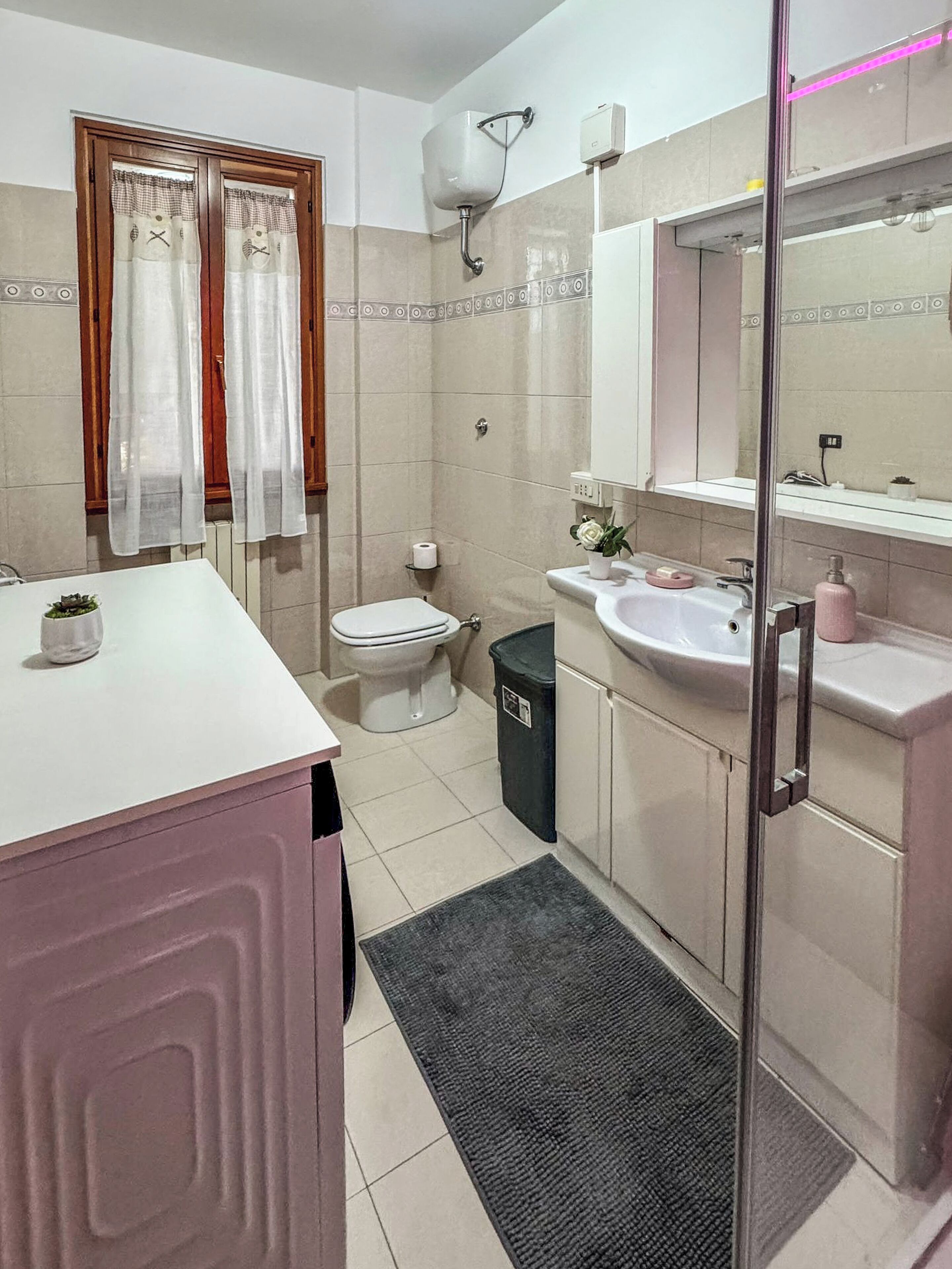 Une salle de bain avec des toilettes, un lavabo et une douche.