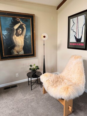 A room with a large classical painting, a modern floor lamp, a small table with a plant, and a fluffy chair. - The Cary Grant Suite at Mountain Daddies B&B (Oakhurst)