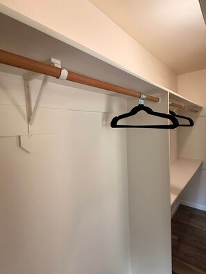 A closet with a wooden rod and black hangers. - Brando King Room at Mountain Daddies B & B (Oakhurst)