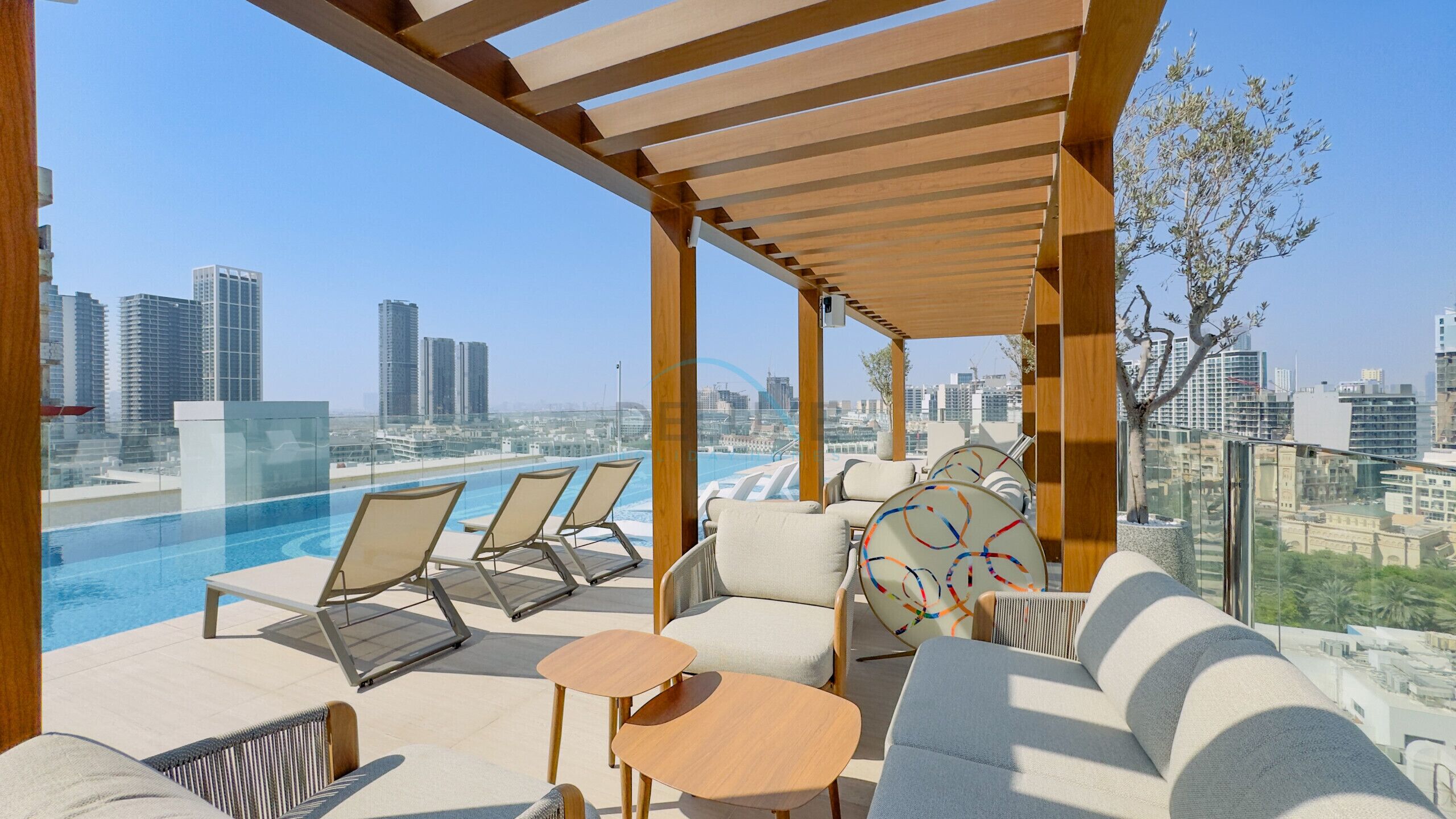 A rooftop pool area with lounge chairs and a city view.