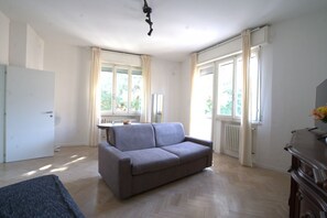 A room with a sofa, a radiator, a window, and a door. - 118 m2 apartment, ideal for up to 7 people, on the 2nd floor of a building with lift.Located in San Giuliano Mare, north of the canal port and a few minutes from the historic center, it enjoys a strategic position that allows you to easily reach the beac (Rimini)