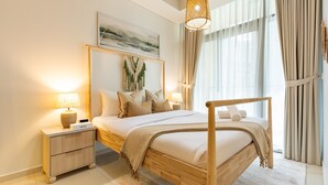 Quarto com cama de madeira, mesas de cabeceira, uma obra de arte na parede e uma janela grande com cortinas.