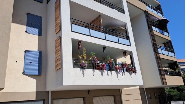 A multi-story building with balconies, some with potted plants. - Beautiful apartment with a piano (Sainte-Maxime)