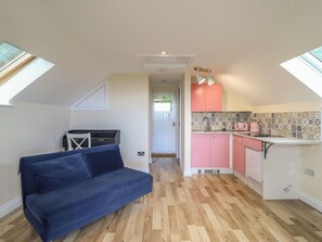 A compact living space with a sofa, kitchenette, and skylights. - Hay Loft at Ebenezer Chapel (Holywell)