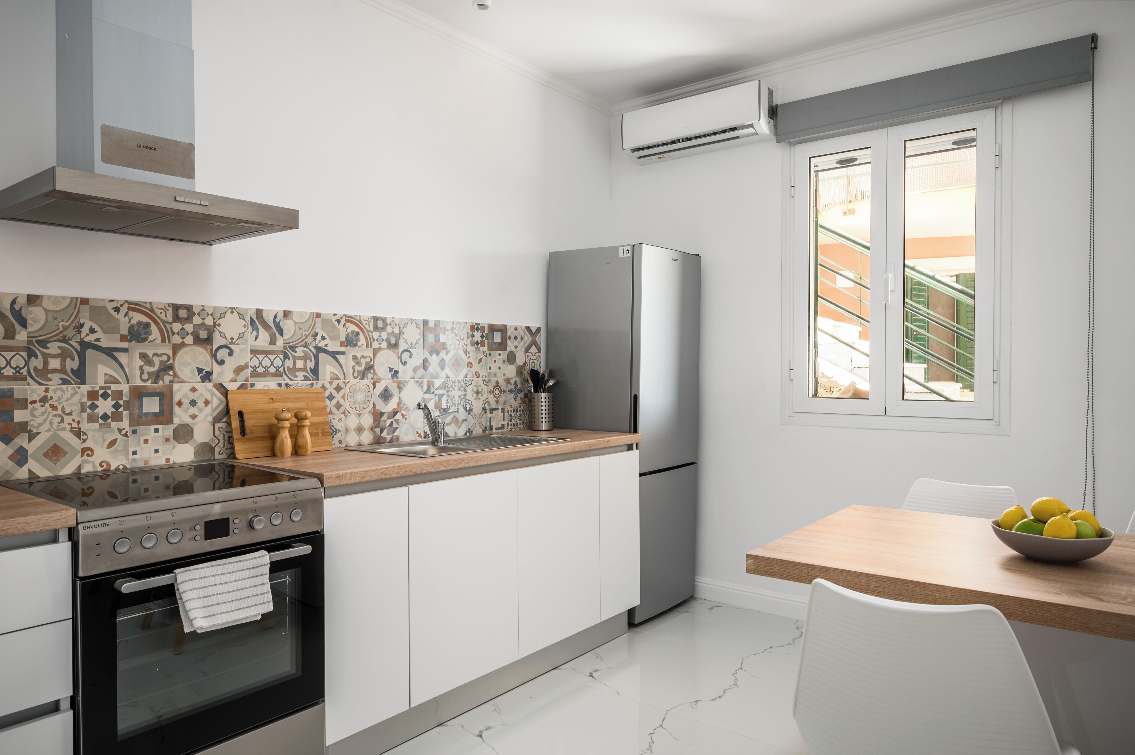 Une cuisine moderne équipée d’une cuisinière, d’un four, d’un réfrigérateur et d’un coin repas avec une table et des chaises.