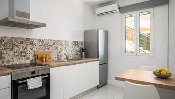 Une cuisine moderne équipée d’une cuisinière, d’un four, d’un réfrigérateur et d’un coin repas avec une table et des chaises.