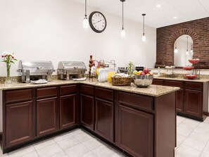 A kitchen with a granite countertop, dark wooden cabinets, a brick wall, a clock, and various food items. - Lovely Albany Room with Breakfast Next Downtown (Albany)