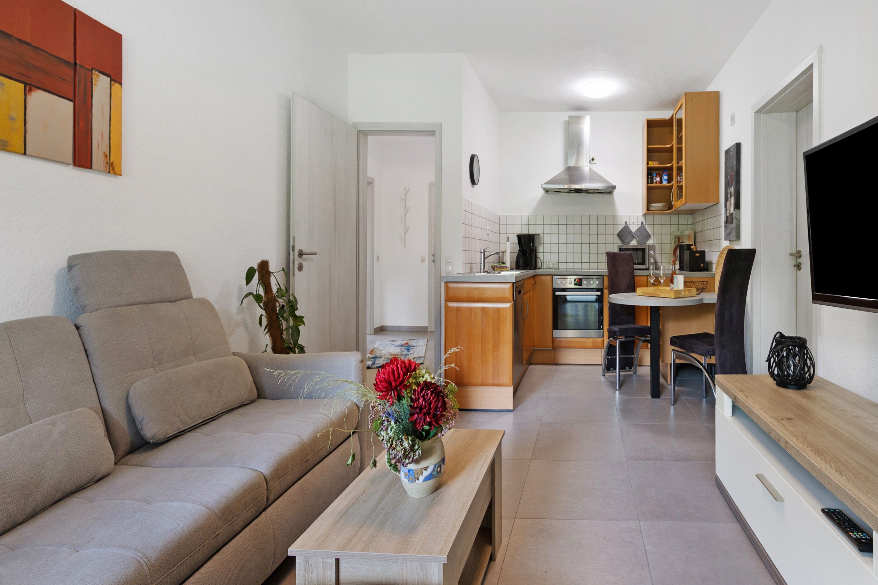 Eine moderne Wohnung mit Wohnzimmer, Küchenzeile und Essbereich.