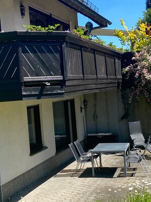 Ein zweistöckiges Gebäude mit Balkon, Außenbereich zum Sitzen und Blick auf den Himmel.