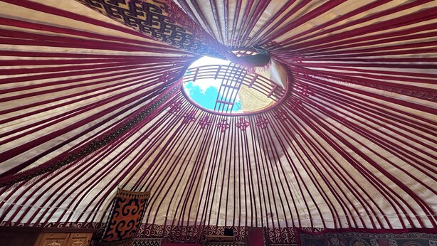Un tragaluz circular con vista al cielo, rodeado por un techo con diseño.