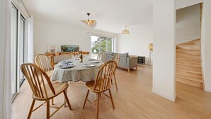 Un'ampia sala da pranzo con un tavolo rotondo, sedie in legno e vista sull'esterno.