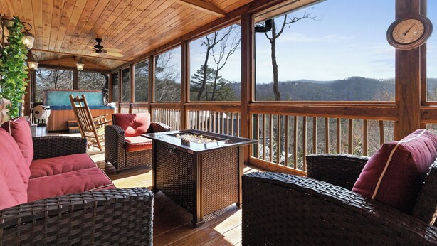 Un espacio al aire libre cubierto con muebles de mimbre, una mesa y un reloj.