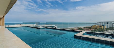 Ein Pool mit Infinity-Kante und freiem Blick auf das Meer und die Skyline der Stadt.