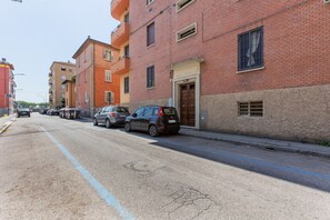 Una strada con auto parcheggiate e edifici a più piani.