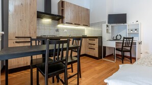 A compact kitchen with wooden cabinets, a dining table, and chairs.