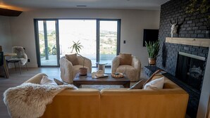 Ein Wohnzimmer mit einer Couch, zwei Sesseln, einem Couchtisch und einem Kamin.