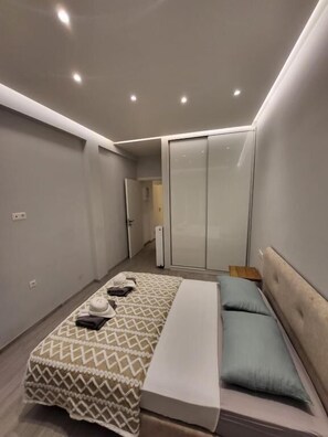 Ein modernes Schlafzimmer mit Bett, Nachttisch, Kleiderschrank und einer Schiebetür.