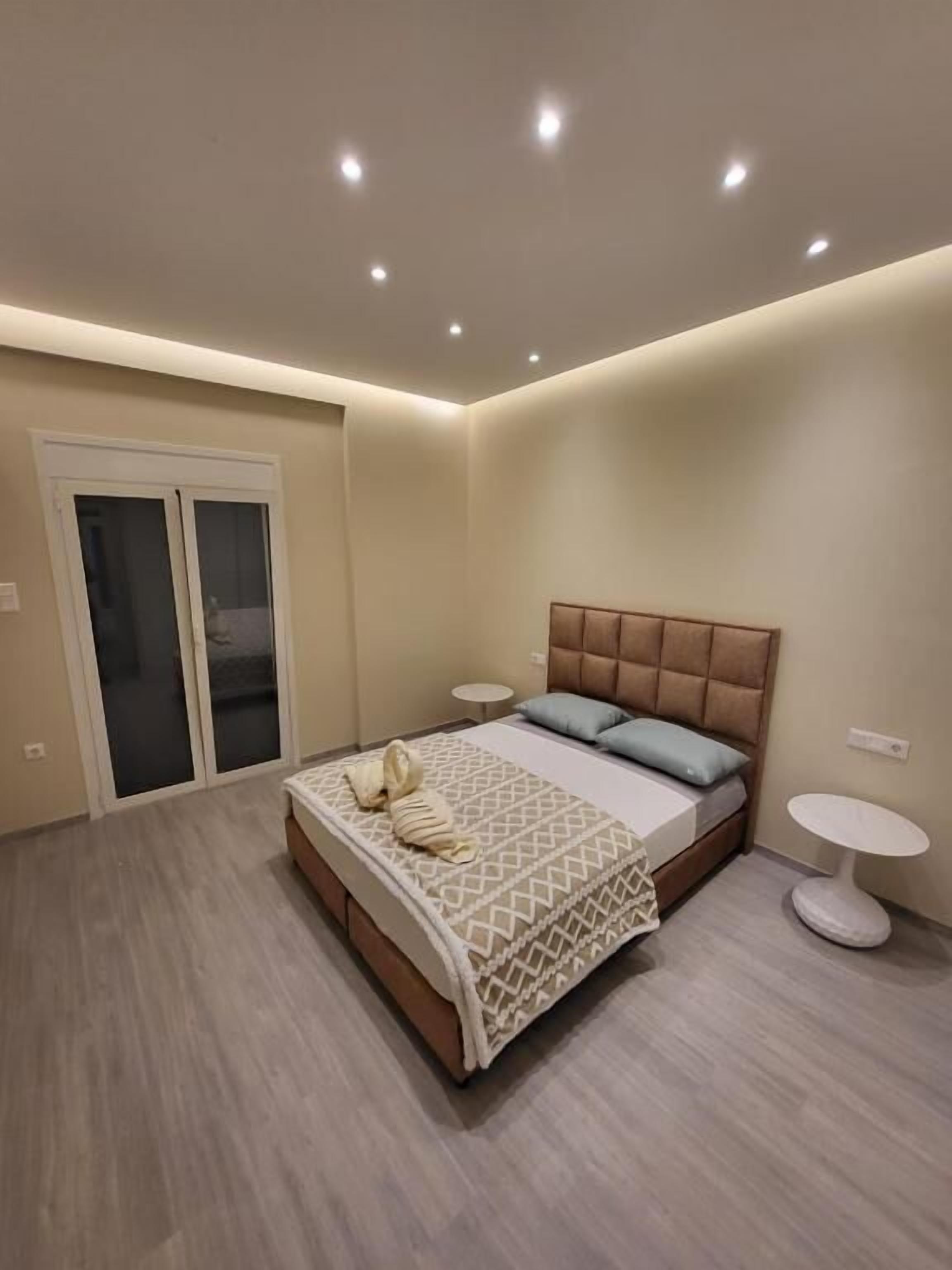 A bedroom with a bed, a small round table, and a door with frosted glass panels.