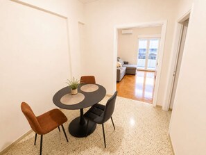 A dining area with a round table, two chairs, and a potted plant. - Boutique 1 Bd Stay in Mavili Square Athens (Athina)