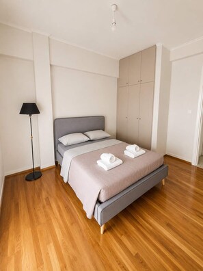 A bedroom with a bed, a wardrobe, and a floor lamp. - Boutique 1 Bd Stay in Mavili Square Athens (Athina)