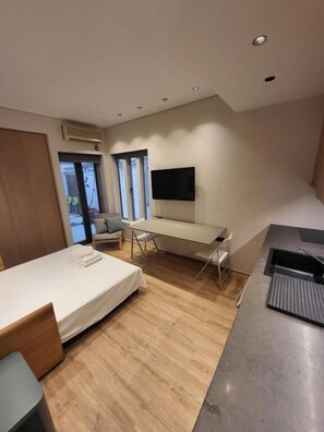 A modern hotel room with a bed, desk, and TV. - Cozy Studio Kolonaki (Athina)