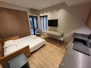 Une chambre d’hôtel moderne équipée d’un lit, d’un bureau, d’une chaise et d’un téléviseur.
