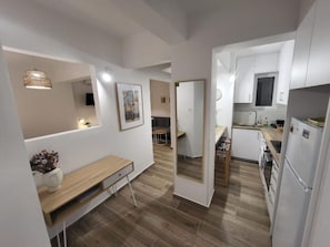 Une cuisine moderne avec des armoires blanches, un plan de travail en bois et un four encastré.
