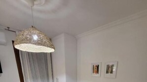 A modern living room with a grey sofa, a wooden coffee table, a hanging light fixture, and a white desk. - Stay Now at Acropolis (Athina)