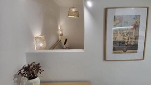 A room with a wooden desk, a mirror, a framed picture, and pendant lights. - Stay Now at Acropolis (Athina)