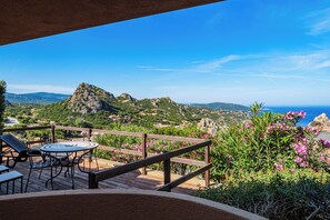 A terrace with a table and chairs, overlooking a mountainous landscape and the sea. - Solo Amore 1  - villa in Costa Paradiso Sardinia residential complex with a pool (Costa Paradiso)