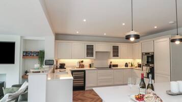A modern kitchen with white cabinetry, a central island, and pendant lighting.